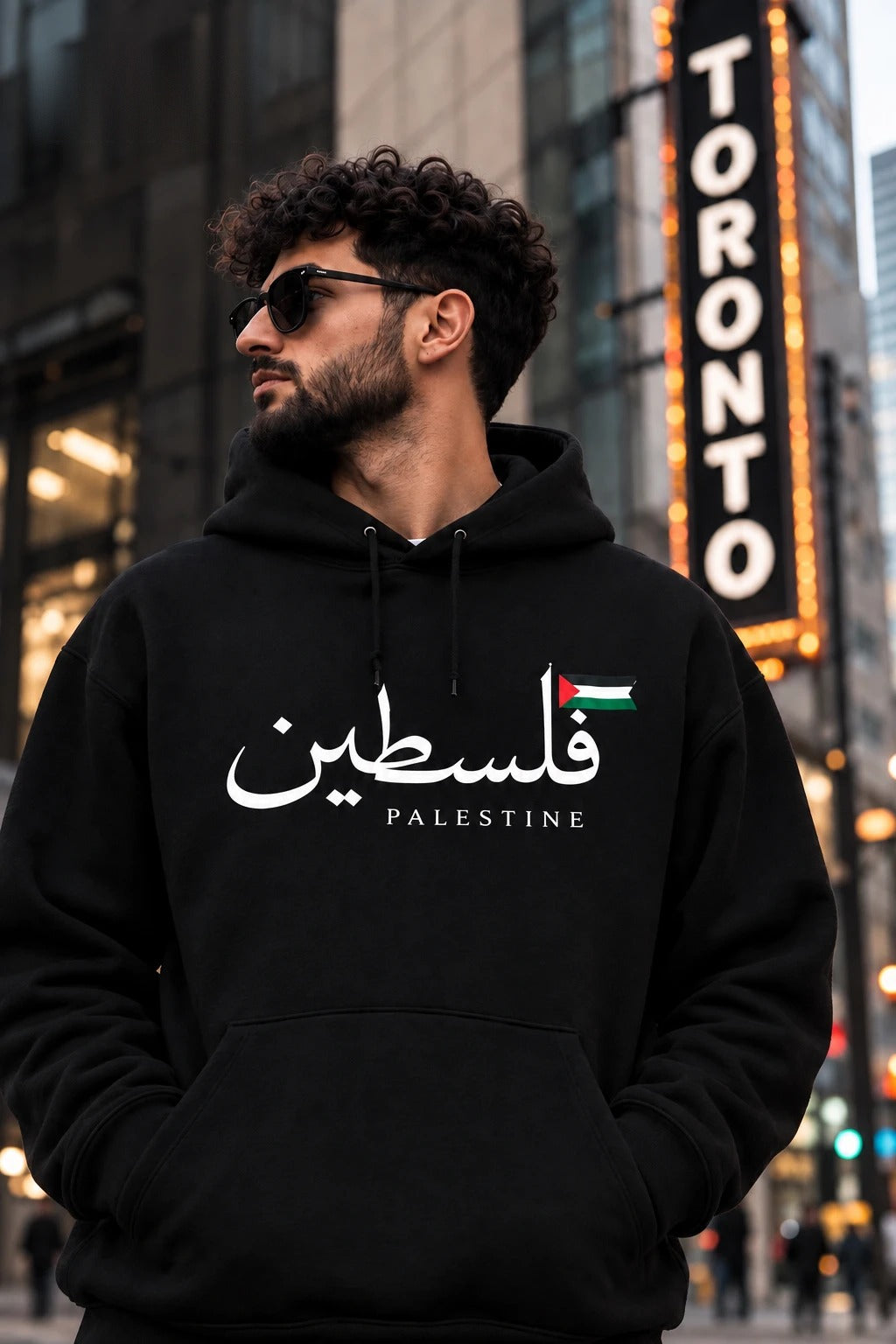 Classic — Filastin black hoodie with Arabic calligraphy and Palestinian flag, worn in Toronto