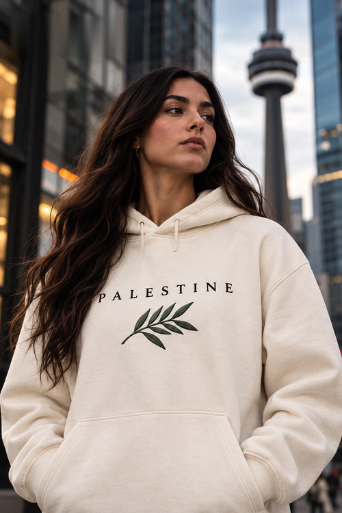 Olive Branch — Zaytoun cream hoodie with PALESTINE and olive branch, CN Tower behind