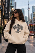 The Roots — Judhour cream hoodie with olive tree and Rooted Elsewhere, Toronto street